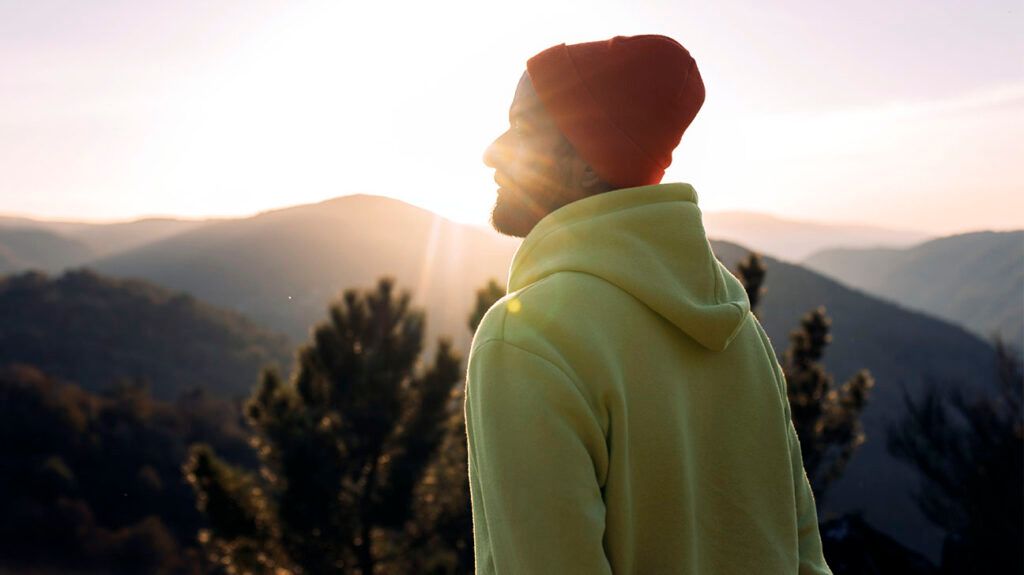 A person enjoying the sunshine and mountains.