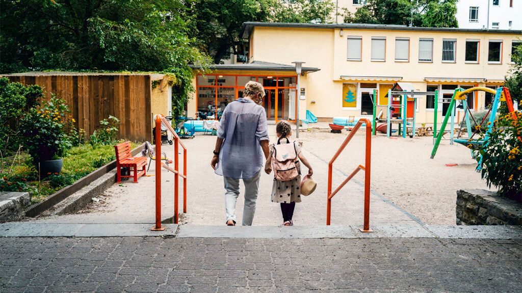 Rear view of an older adult with a child at the park.