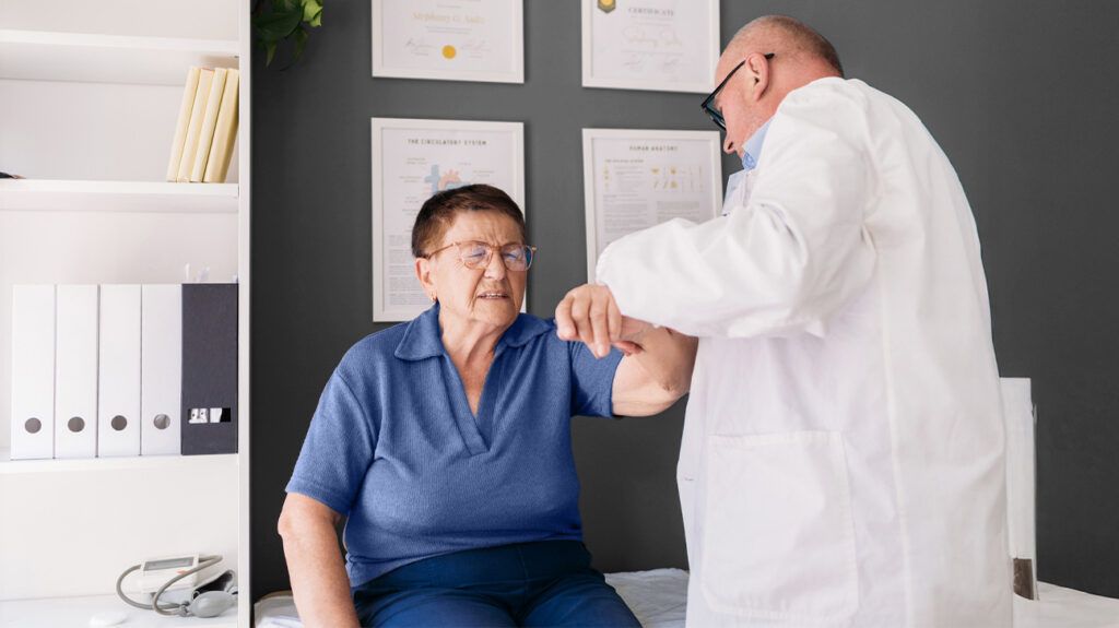 A healthcare professional examining a persons shoulder 1