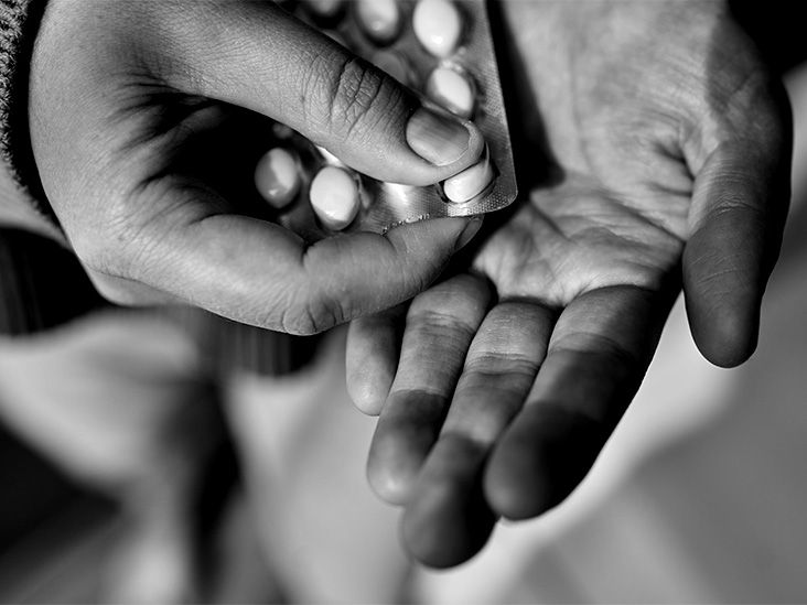 A person is removing a tablet from a pill pack and placing into their hand,