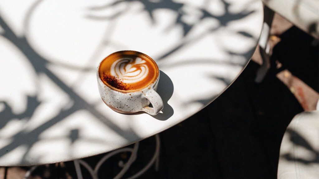 A cappuccino in a ceramic mug on a white table