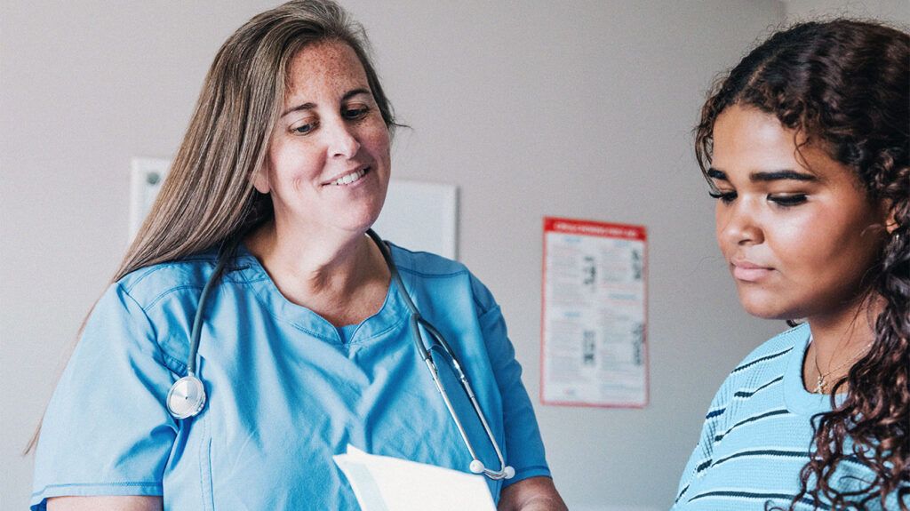 A teen girl talking with a doctor-1
