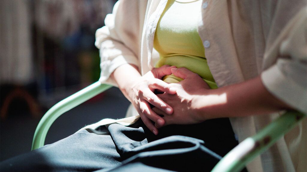 a person clutching their belly in pain-1