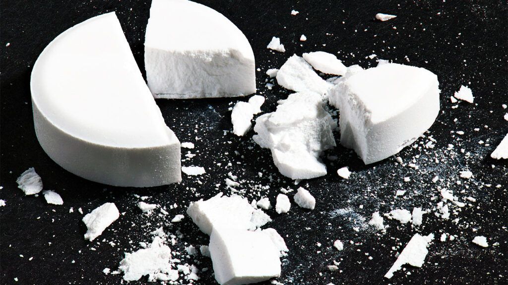 broken aspirin tablet against black background