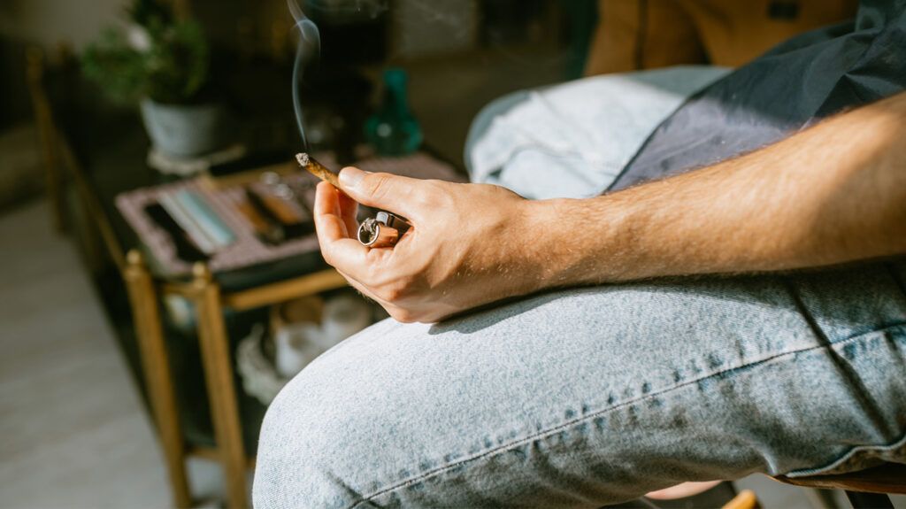 person smoking cannabis cigarette, face not shown