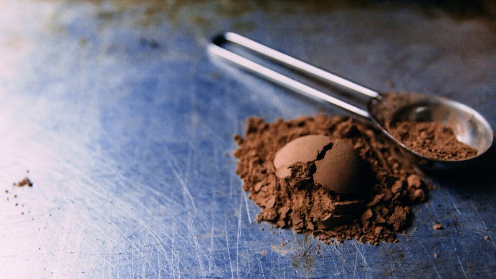 Cocoa powder and a measuring spoon on a chopping board