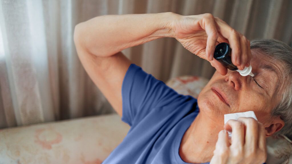 An older adult putting in eye drops