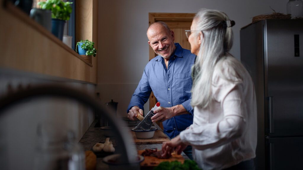 older straight, white couple pictured cooking together in their kitchen