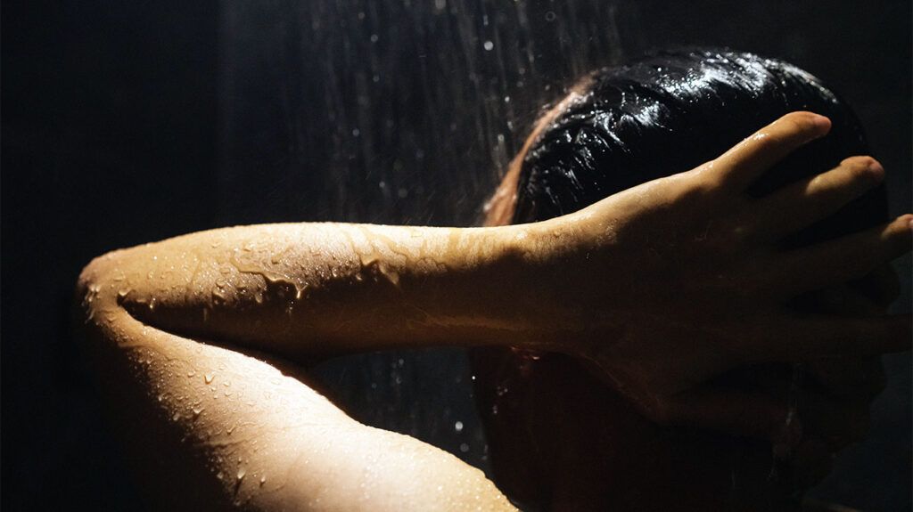 a person washing their hair in a shower-1