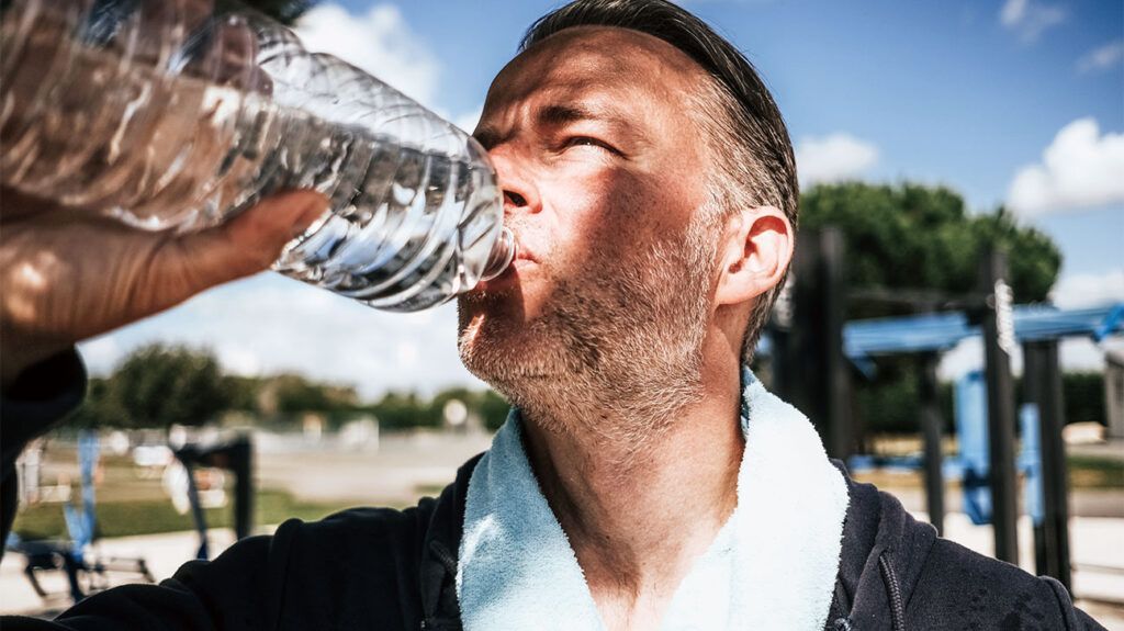 Adult man drinking a bottle of water