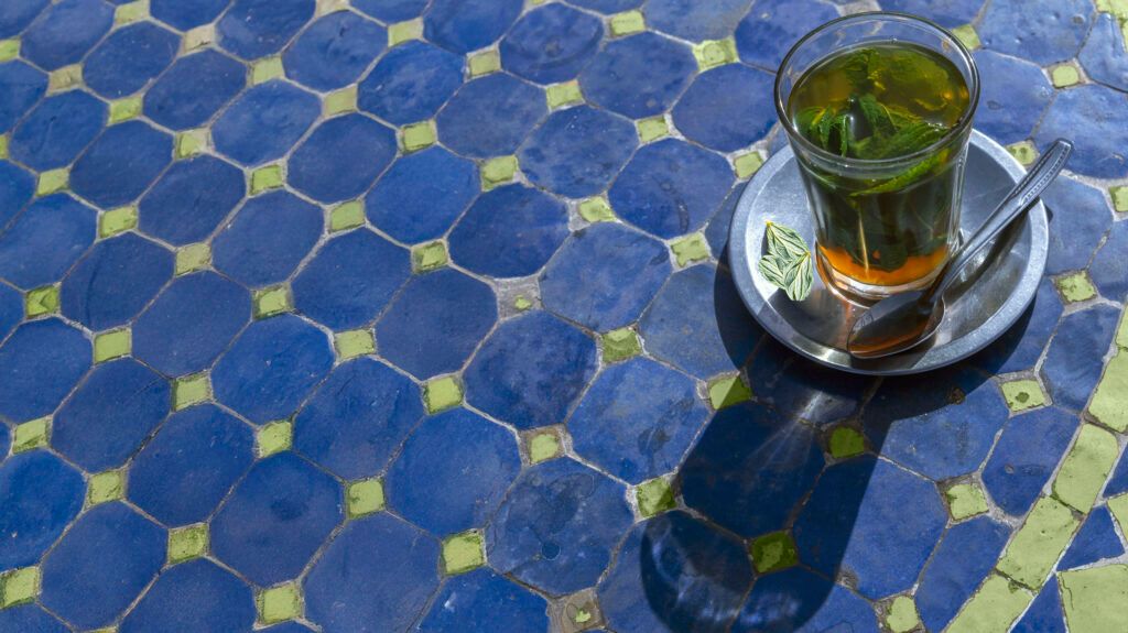 A glass of peppermint tea on a blue tablecloth.-2
