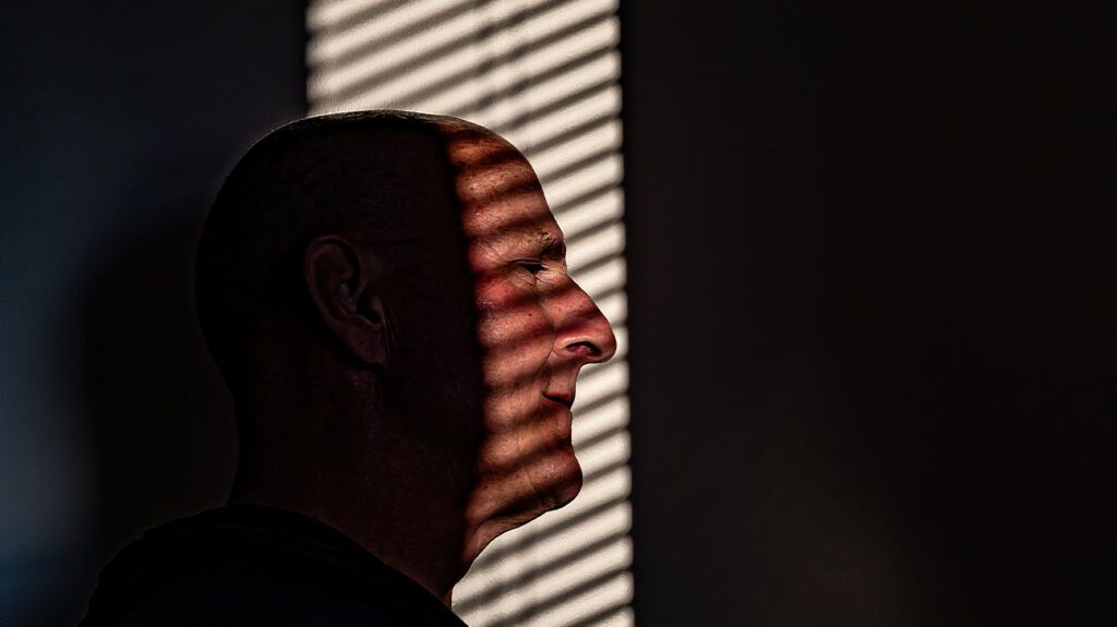 older white man seen from the profile in semi shadow