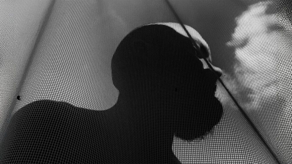 A man's silhoutte through netting
