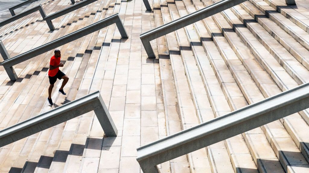 Black man running up a flight of stairs