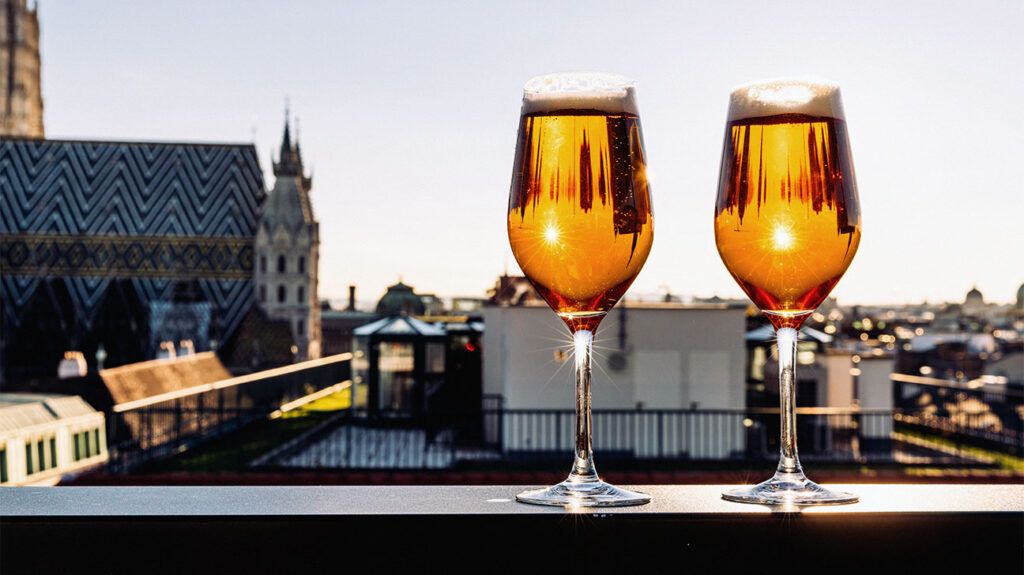 two glasses of beer against a city backdrop-1