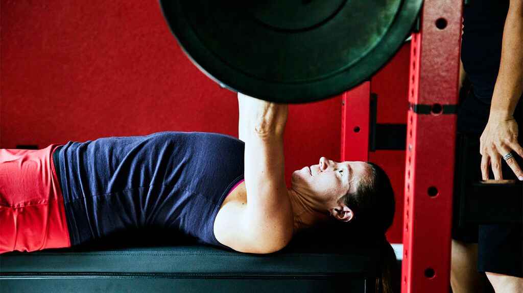 A person lying on their back pushing up a weight.-3