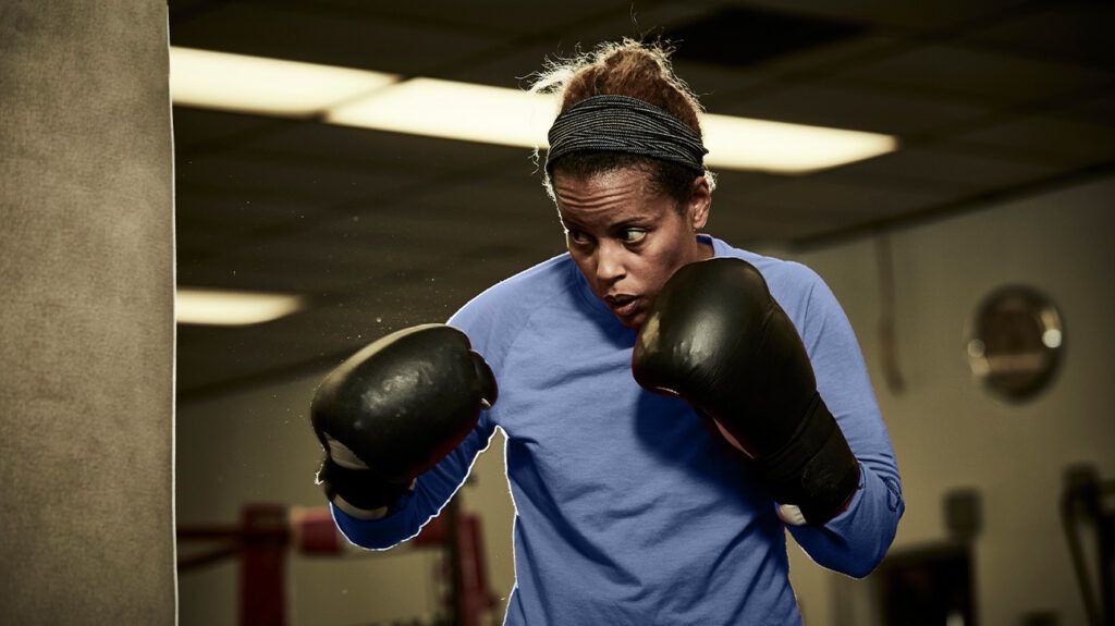 A person boxing with boxing gloves at a gym
