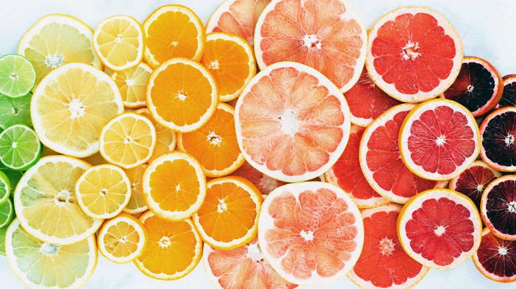 Flat lay of slices of citrus fruit, including limes, oranges, and pink grapefruit.