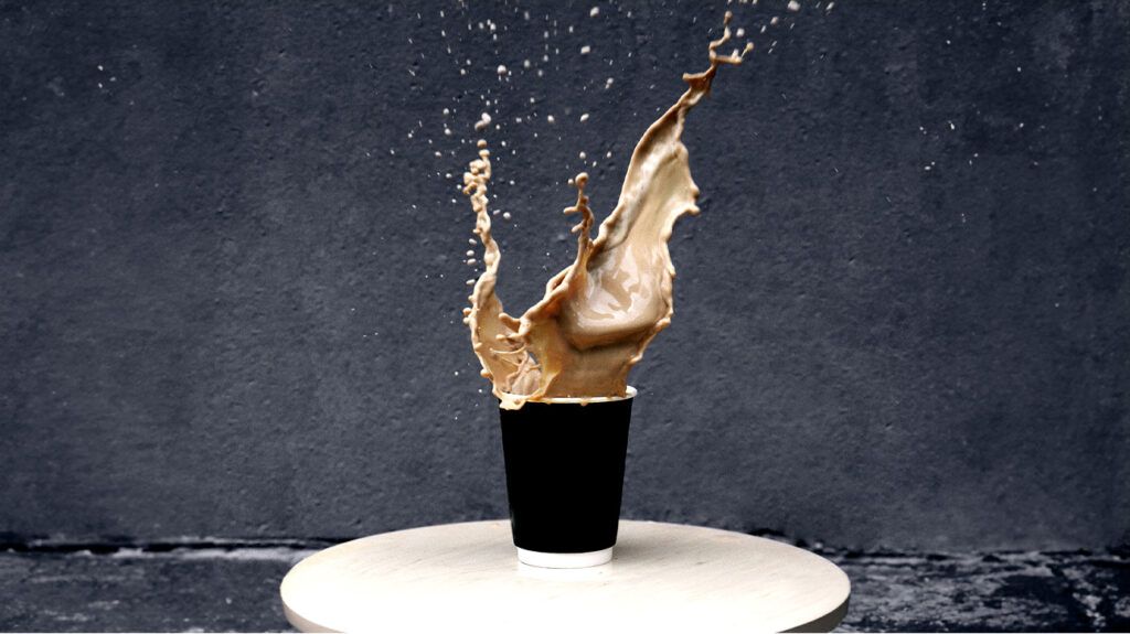 A cup of coffee captured just before the liquid spills