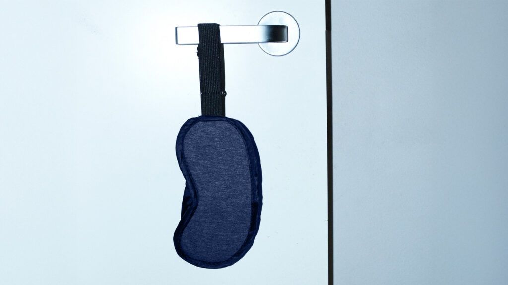 eye mask for sleep hanging from door handle
