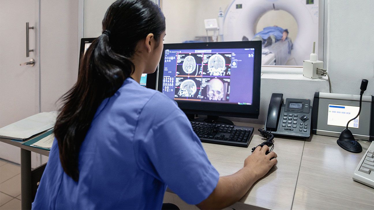 A healthcare professional looking at a brain CAT scan 1