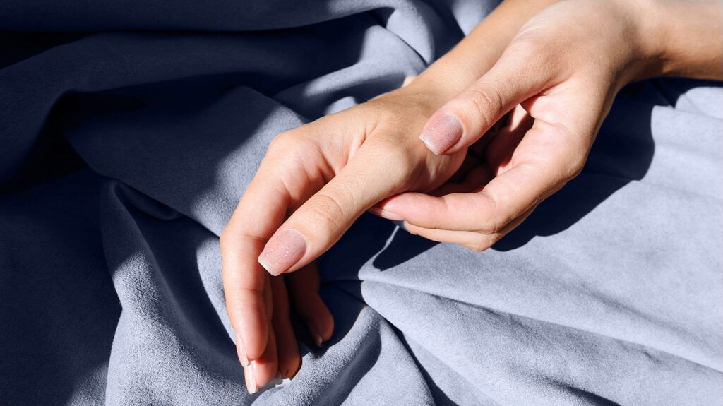closeup of hands on blue blanket