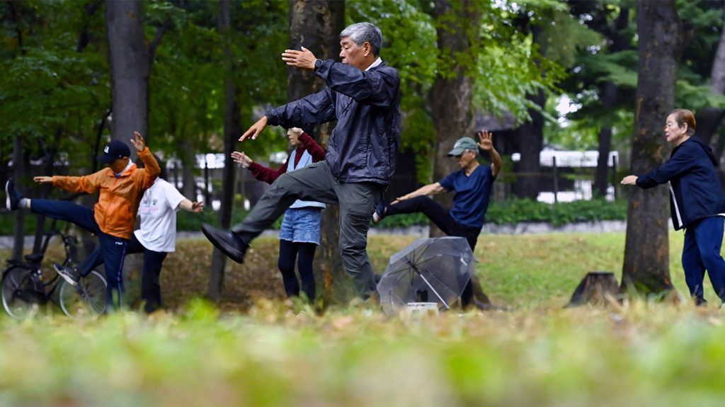 Older adults exercising in a park.