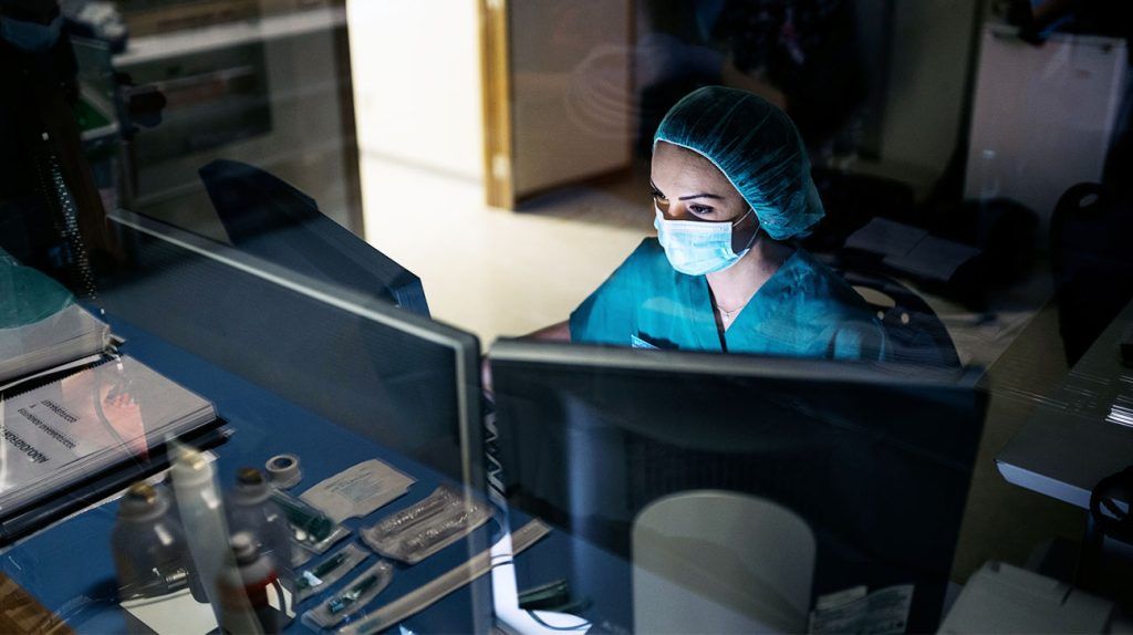 A healthcare professional looking at scan results on a monitor.