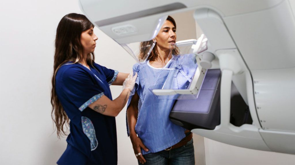 A person receiving a mammogram.