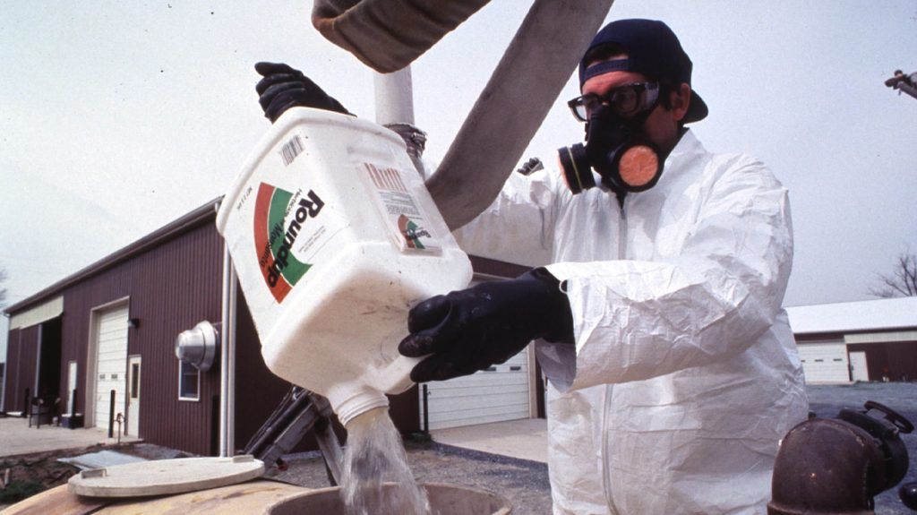 A farm worker using pesticide.
