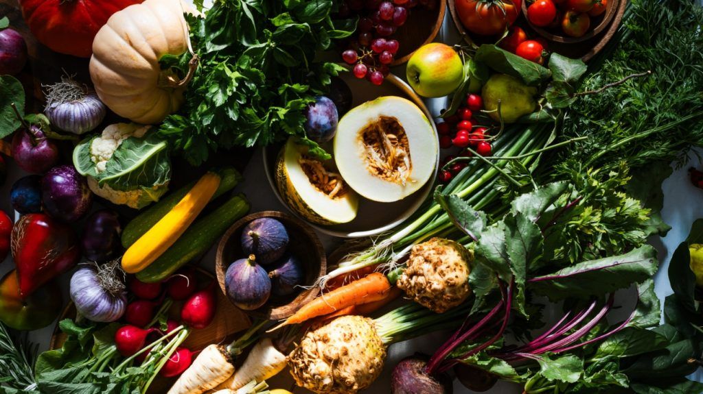 Fresh homegrown vegetables and fruits, including melon, figs, and grapes, foods that are rich in antioxidants,viewed from above.