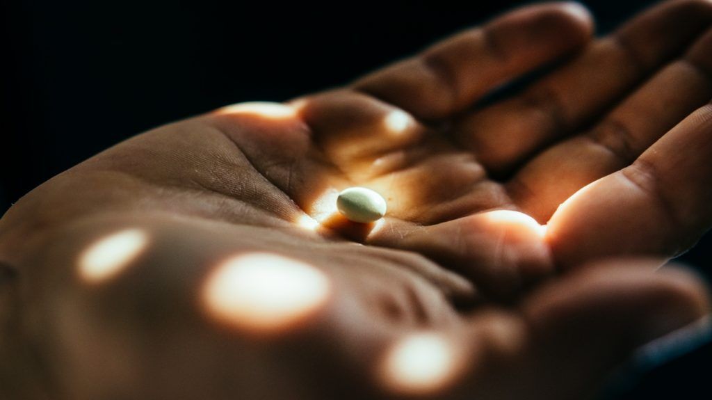 close-up of pill in an outstretched palm
