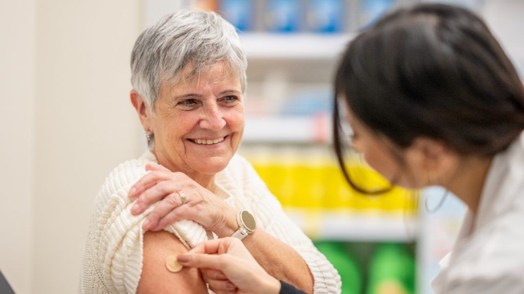 A older woman is getting a vaccine.