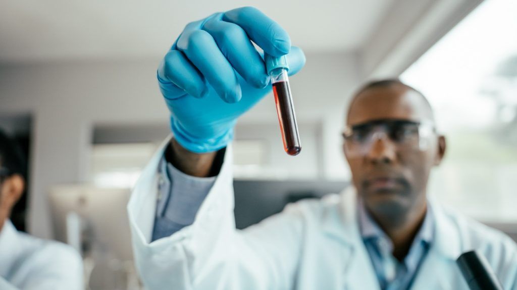 A lab technician looking at a blood sample.