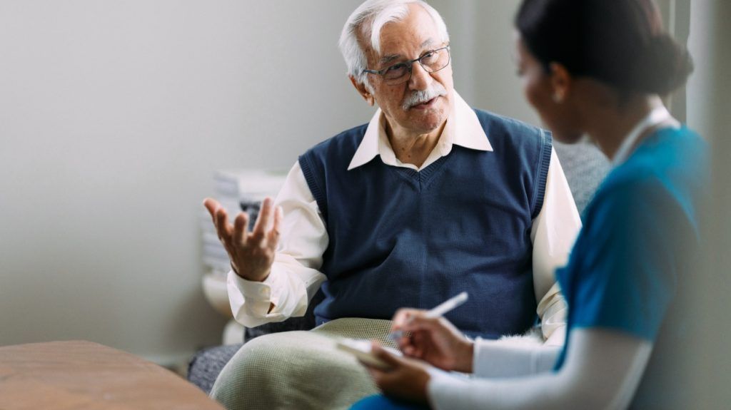 An older patient is talking with a medical professional.