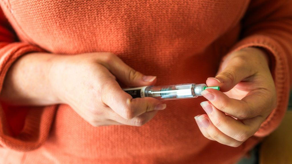 A person prepares to inject a GLP-1 drug to lose weight and manage diabetes