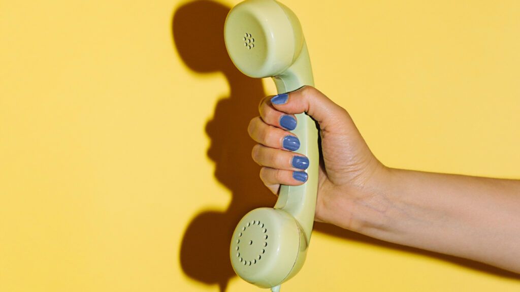 a hand holding a vintage phone handset