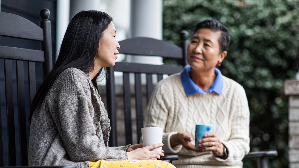 Mother and adult daughter chatting in a porch