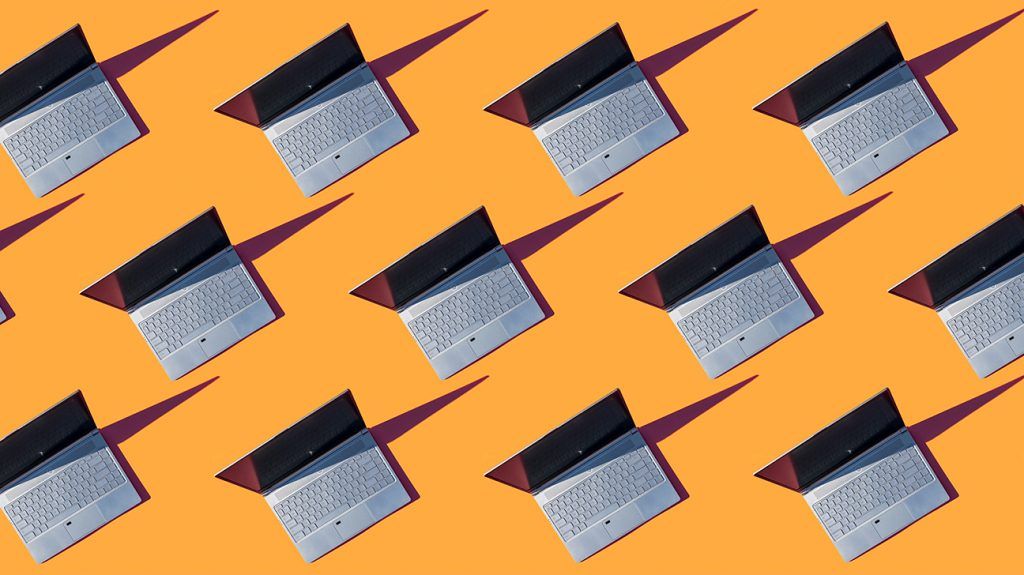 Rows of open laptops on an orange background