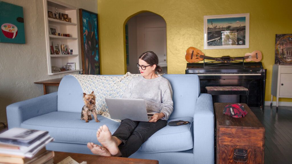 Woman with small dog in living room