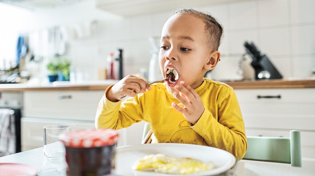 Young kid eating egg