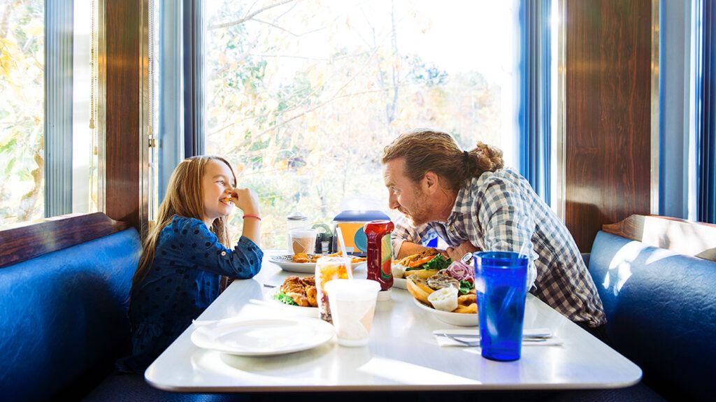 Father and daughter eating in restaurant