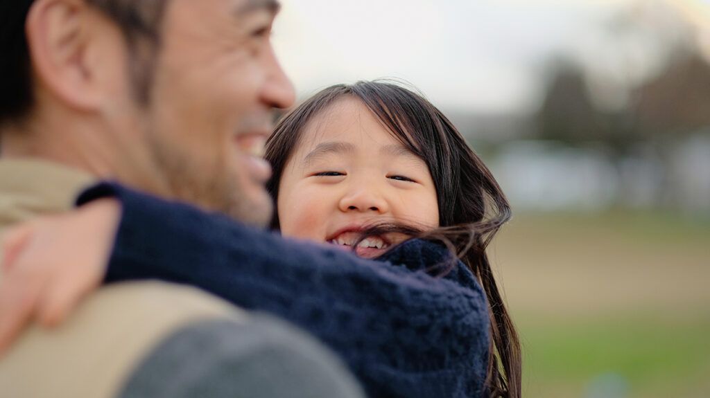 Father and daughter hugging at park