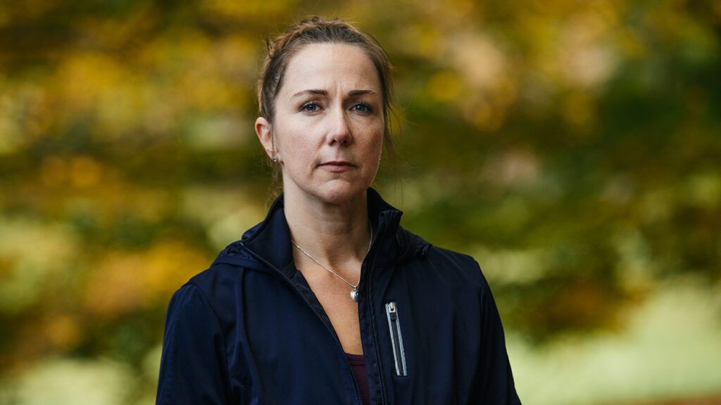 Mature woman standing outdoors in fall