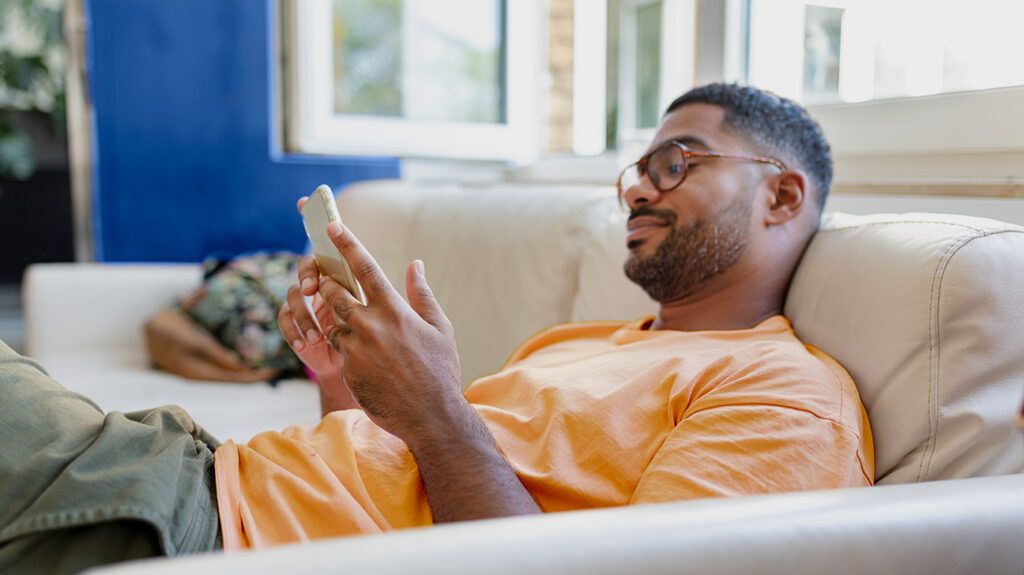 Relaxed person on a couch using their phone to find best ADHD apps.