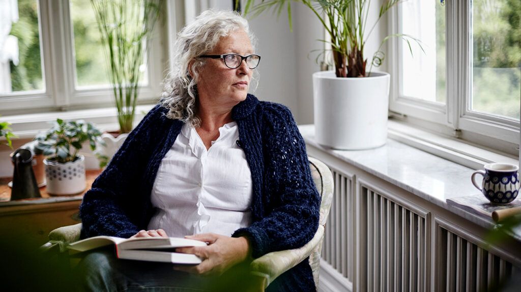 Woman staring out the window contemplating why she's feeling left out with her freinds