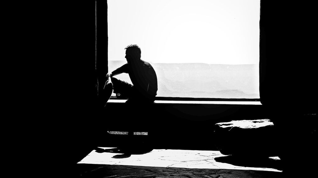 Silhouette of man sitting at window