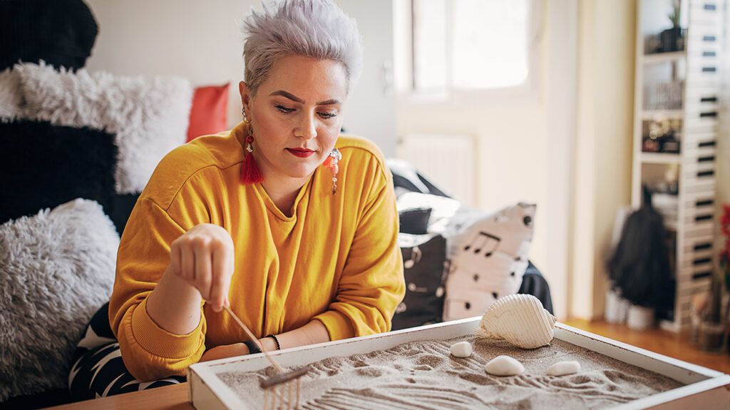 Person using a Zen garden for stress relief