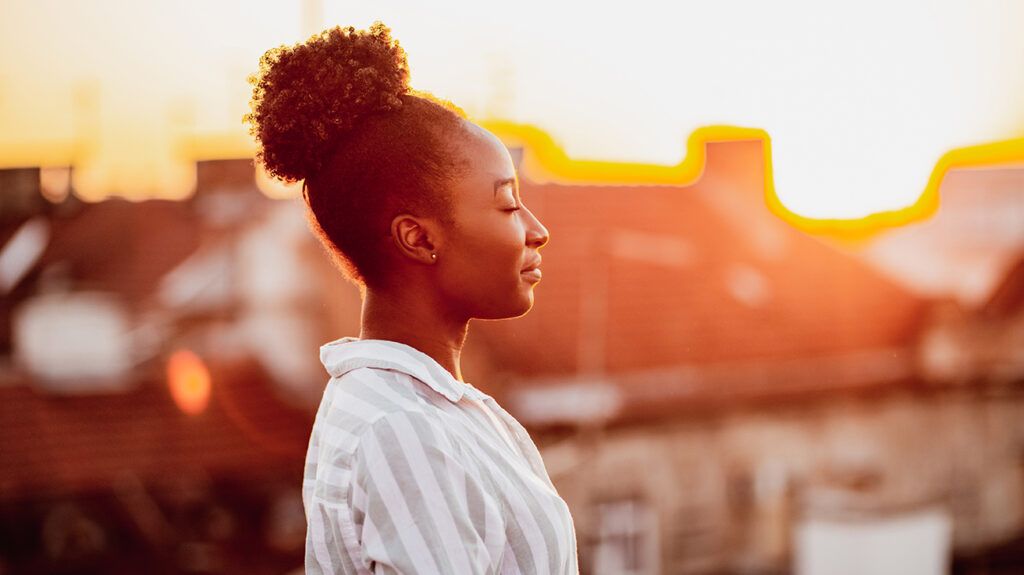 Young woman on rooftop at sunset