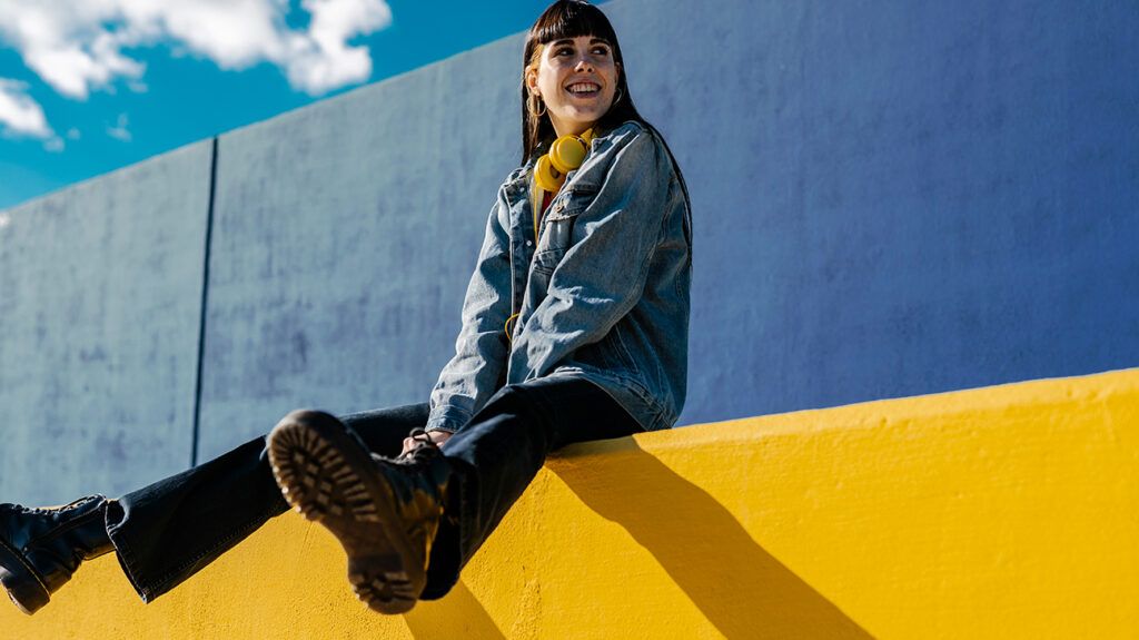 Happy woman smiling on yellow wall